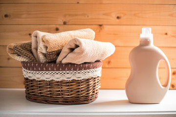 Fototapeta na wymiar Bottle of detergent and towels in basket.