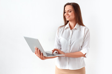 Modern technology. Woman standing isolated on white browsing internet on laptop joyful