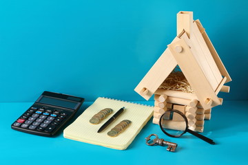 Fototapeta premium Model of log house and an iron key on the wooden background. Business concept.