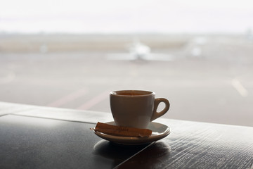 Cup of coffee on the table in airport cafe.