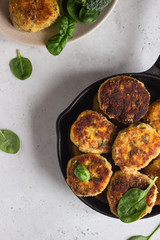 Delicious fried meat cutlets. Chicken or turkey cutlets with carrot and spinach served with broccoli, spinach and sour cream sauce. Light grey concrete background.