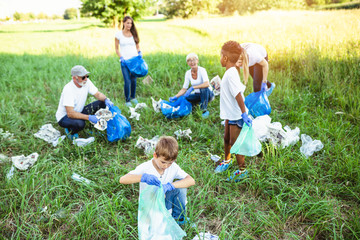Fototapeta premium Volunteers with garbage bags cleaning up garbage outdoors - ecology concept.