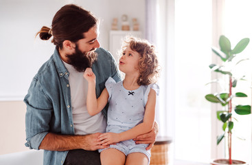 A small girl with young father at home, talking. Copy space.