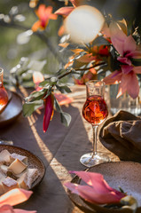 Beautiful table setting in garden on sunset light. Table decorated with magnolia flowers under magnolia tree.