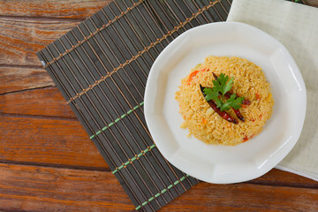 Top view Tomato fried rice served with red dried chili in white dish on wooden table. Copy space...