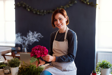 Young creative woman in a flower shop. A startup of florist business.