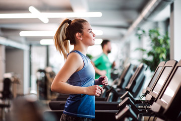 Un portrait de jeune fille ou femme faisant de l& 39 exercice cardio dans une salle de sport.