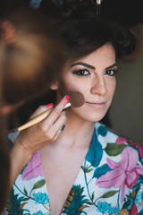 Young woman getting her make up