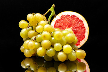 grapes and grapefruit black background