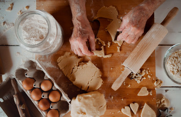 Midsection of old woman making cakes in a kitchen at home. Top view.