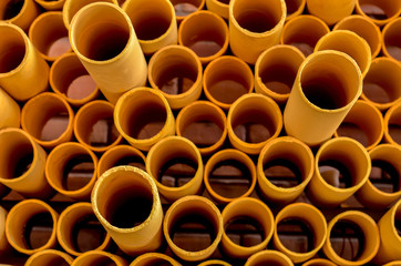 Front view of abstract art structure created by stacking yellow PVC pipes together at an exhibition