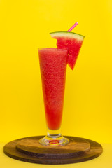 Healthy watermelon smoothie in glass with watermelon and straw on yellow background,healthy detox or diet concept