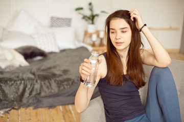 Sports girl with dark hair holding bottle of clear water healthy food, healthy lifestyle