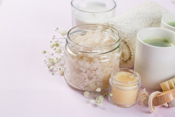 SPA concept - towel, salt, candle on pink background, copy space