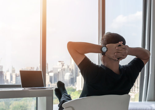Life-work balance and city living life style concept of business man relaxing, take it easy in office room resting with thoughtful mind thinking of lifestyle quality looking forward to cityscape 