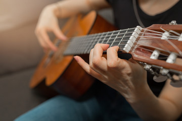 girl playing guitar at home