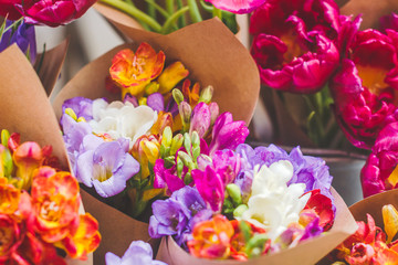 Bouquet of colorful fresh freesia in a craft paper