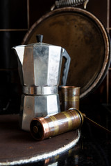 Moka pot on a stove with coffee grinder