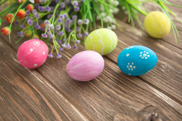 Easter eggs and flowers on rustic wooden planks