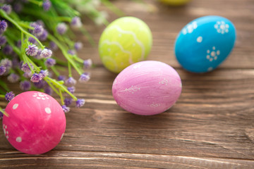 Colorful easter eggs and flowers on rustic wooden planks