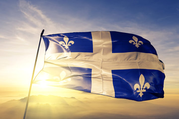 Fototapeta premium Flaga prowincji kanadyjskiej prowincji Quebec macha na szczycie mgły o wschodzie słońca