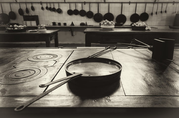 vintage looking image of an antique XIX century old kitchen with tools, pans, pots and food...