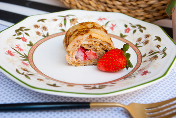 Chef dessert pancakes rolls with strawberry. Food photo.