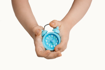 children's hands holding a blue clock isolate.