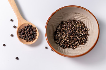 finely ground black pepper in bowl on white background