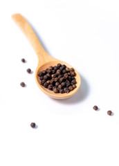 black pepper in spoon on white background