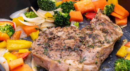 Cooking fried pork steak with colorful pepper and onion