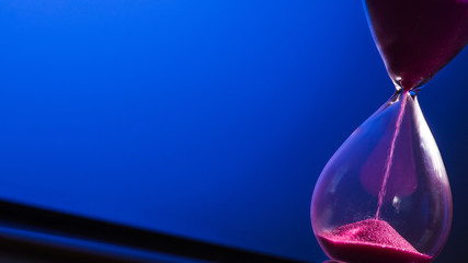 Bright colored pink sand with hourglass