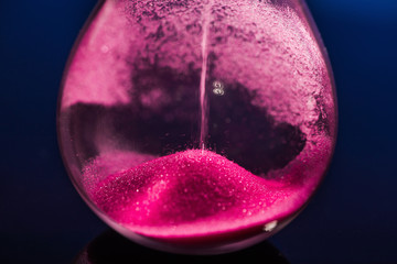 Bright colored pink sand with hourglass
