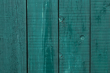 Fototapeta na wymiar Wooden fence cracked paint. Rough wooden boards painted green. Wood texture background, oak wood wall fence. Green wooden fence rough wood. Wooden background. Vintage wooden fence rough wood. Exterior