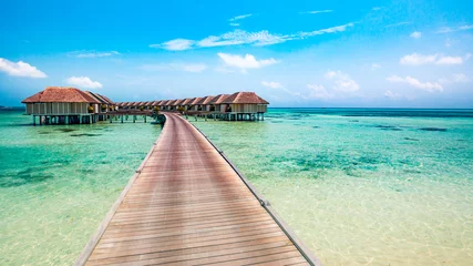 Fotobehang Landscape of Maldives beach. Tropical panorama, luxury water villa resort with wooden pier or jetty. Luxury travel destination background for summer holiday and vacation concept © icemanphotos