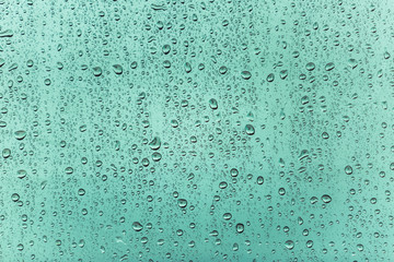 Water drops of rain on blue glass background 