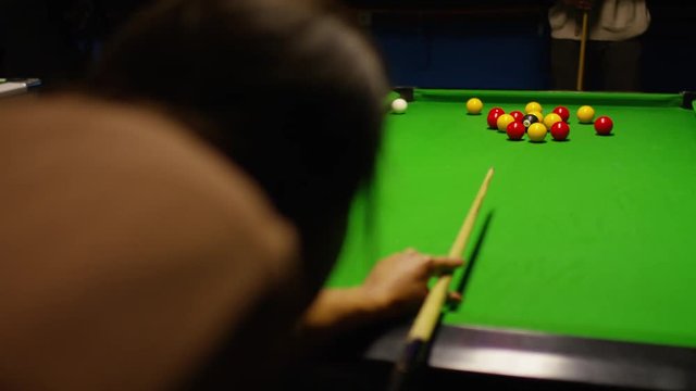 Female making  break on a billiards table in a pool hall