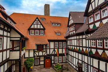 The castle courtyard of Ludwigstein Castle, surrounded by half-timbered buildings. Taken from an elevated position on a nice sunny day with blue sky in Germany. 