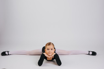 A young ballerina stretching on the floor