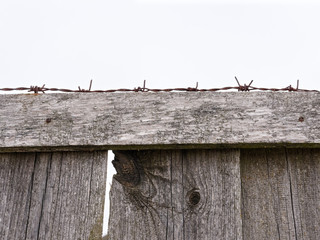high fence with barbed wire on a white background.