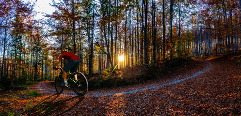 Cycling man riding on bike at sunset mountains forest landscape. Cycling MTB enduro flow trail track. Outdoor sport activity.