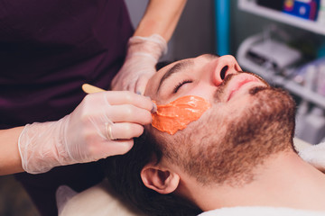 Hair removal. Man's face sugaring epilations beard trimming, yellow color, in cosmetology on the...