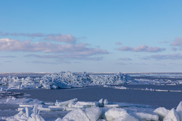 Fototapeta premium Seaside with frozen and melting ice with rocks