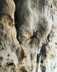 Girl rock climber climbs difficult route on the cliffs