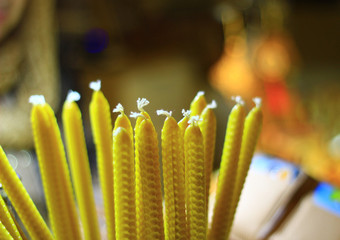 Unblown church candles are yellow with white wicks on the ends