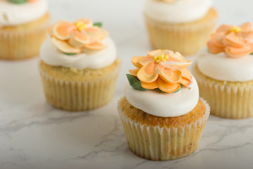 Obraz na płótnie Canvas Lemon Cupcakes With Buttercream Flowers On Marble Table
