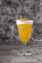 Alcohol drink with lemon, rosemary and ice on rustic black stone table, copy space, top view. Iced drink with lemon and herbs.