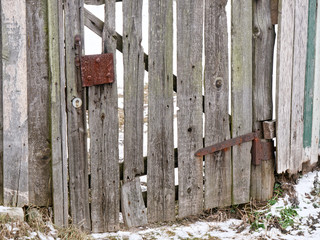 old wooden door of an old plank fence.
