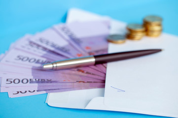 pen white envelope and cash on Desk
