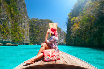 Beautiful woman travelling by boat among the islands Phi Phi and Maya beach in Thailand.